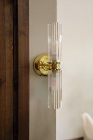 Rimini 35cm Messing badeværelseslampe Fra Markslöjd - Rimini er en elegant v&aelig;glampe med stilfulde detaljer i messingfinish og to aflange sk&aelig;rme i klart, riflet glas.