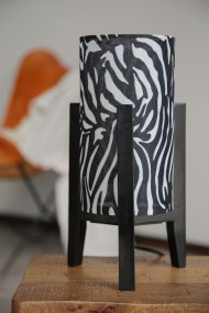 Eruca 34cm Zebra bordlampe Fra Markslöjd - Den sorte tr&aelig;base er kombineret med en cylindrisk tekstilsk&aelig;rm i et sort-hvidt zebram&oslash;nster, hvilket giver lampen en grafisk og udtryksfuld karakter.