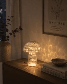 Svamp 23cm Blå bordlampe Fra Pixie Design - Den er udstyret med en timer og en praktisk 5-trins lysd&aelig;mper til at justere lyset efter behov, hvilket g&oslash;r den perfekt til b&aring;de arbejdsbelysning og hyggelig aftenbelysning.