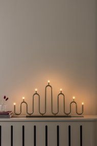 Noel 7 Messing Fra Globen Lighting - Det bløde, bølgede design er skabt af metalrør, der er bøjet i hånden på forskellige niveauer, og giver en moderne fortolkning af den klassiske adventslysholder.