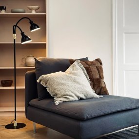 Lilje Sort gulvlampe Fra Dyberg Larsen - Lily golvlampa i svart och m&auml;ssing kombinerar modern design med flexibilitet och funktionalitet.