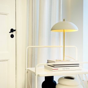 Globus 44cm Messing/beige bordlampe Fra Dyberg Larsen - Lampen er lavet af metal og kombinerer en bl&oslash;d beige tone med detaljer i messingfinish, hvilket giver et harmonisk og moderne udtryk.