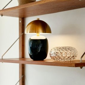 Manhatten 23cm Sort/messing bærbar Fra Dyberg Larsen - Lampen er fuldt opladet p&aring; cirka 8 timer og lyser i op til 40 timer ved laveste lysstyrke og op til 8 timer ved h&oslash;jeste.