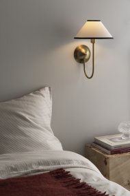 Iris 32cm Messing/cremehvid væglampe Fra Globen Lighting - Den blødt buede arm er kombineret med en cremehvid tekstilskærm, der skaber et varmt og klassisk udtryk.