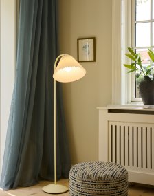 Medina Cremet hvid gulvlampe Fra Halo Design - Den cremehvide metalramme suppleres af en smuk plisseret tekstilskærm i matchende skærm og dekorative detaljer i messing.