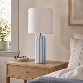 Faro 50cm Lyseblå/hvid bordlampe Fra Nordic Lighting - Lampefoden er lavet af keramik med en cremet hvid base og lysebl&aring; striber, der giver et livligt, men afbalanceret indtryk.