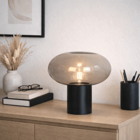 Alba 32cm Sort/Røget bordlampe Fra Nordic Lighting - Den sorte metalbase giver et stabilt og elegant udtryk, mens den r&oslash;gede glassk&aelig;rm skaber et bl&oslash;dt og atmosf&aelig;risk lys.