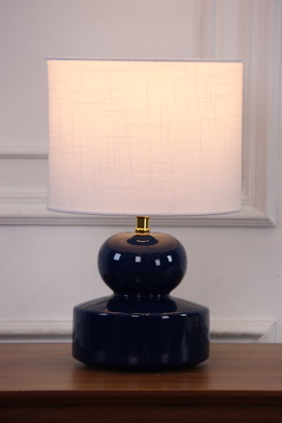 Muschi 36cm Blå bordlampe Fra Nordic Lighting - Muschi bordlampen har en bl&aring;, blank keramisk base med bl&oslash;dt afrundede former og en hvid linnedsk&aelig;rm.