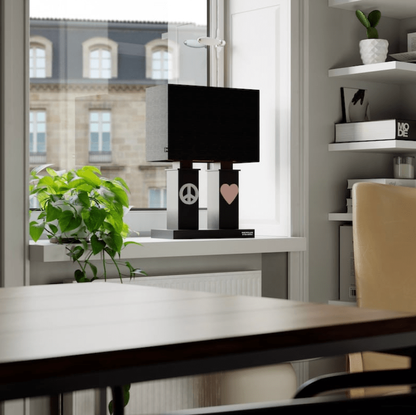 Stand By Me 50cm Sort bordlampe Fra By Rydéns - Den brede, sorte stoflampesk&aelig;rm harmonerer i kontrast til de smallere s&oslash;jler p&aring; lampefoden, som begge er dekoreret med et symbol i metal, fredstegn p&aring;; et og et hjerte p&aring; den anden.