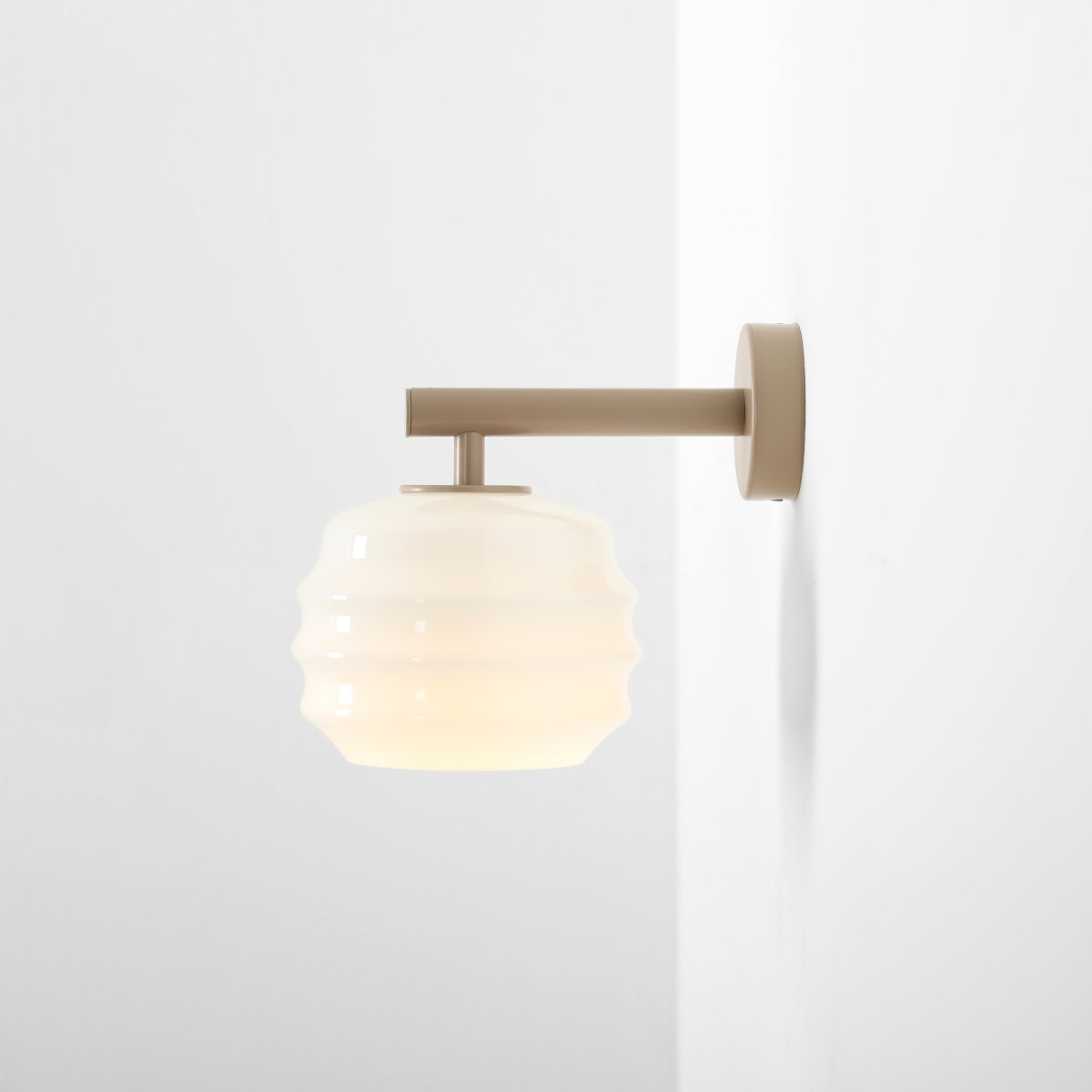 Puff 23cm Beige væglampe Fra Artera - Den dekorative skærm i hvidt opalglas har en bølget form, der giver lampen et legende og elegant udtryk.