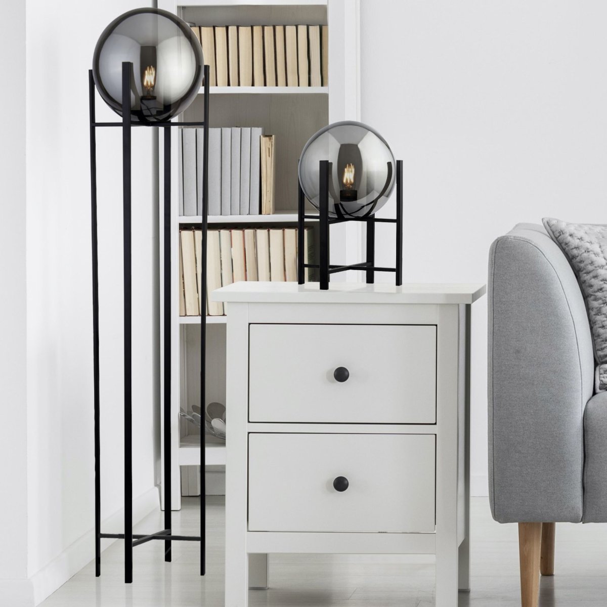 Amsterdam Sort gulvlampe Fra Searchlight - Med en røget isvaffel, der hviler på; en slank, sort metalramme giver lampen en stilfuld og mystisk lyseffekt, der passer perfekt i både moderne og industrielle miljøer.