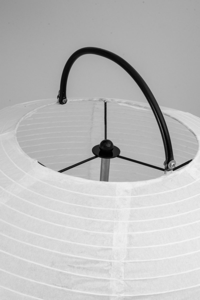 Osaka Hvid gulvlampe Fra Globen Lighting - Lampen er lavet af hvidt rispapir og har et dekorativt greb i matsort lakeret metal og et matchende stativ i bunden, som papirskærmen hviler på.
