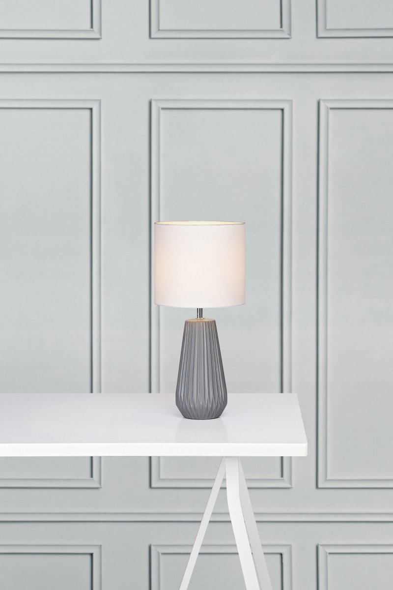 Nicci 40cm Grå bordlampe Fra Markslöjd - Den minimalistiske form gør lampen alsidig og nem at placere i både stuer og soveværelser, og den er særdeles velegnet til dem, der leder efter en tidløs og funktionel belysningsløsning.