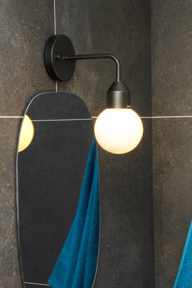 Florens Ø12 Sort badeværelseslampe Fra Aneta Lighting - Florens er en stilfuld badeværelseslampe i sortlakeret metal med en rund kuppel i opalhvidt glas, der spreder et blødt og behageligt lys.