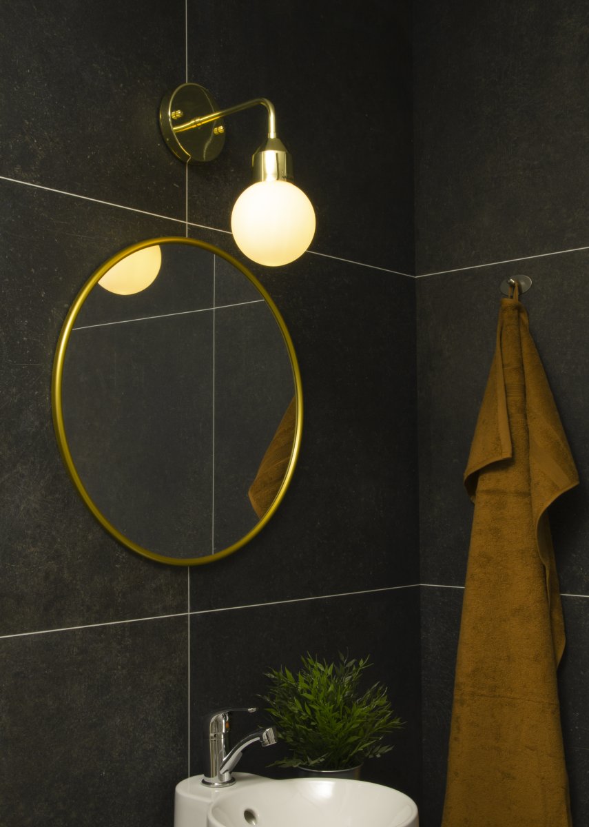 Florens Ø12 Messing badeværelseslampe Fra Aneta Lighting - Florens er en stilfuld badeværelseslampe i messingfarvet metal med en rund kuppel i opalhvidt glas, der spreder et blødt og behageligt lys.