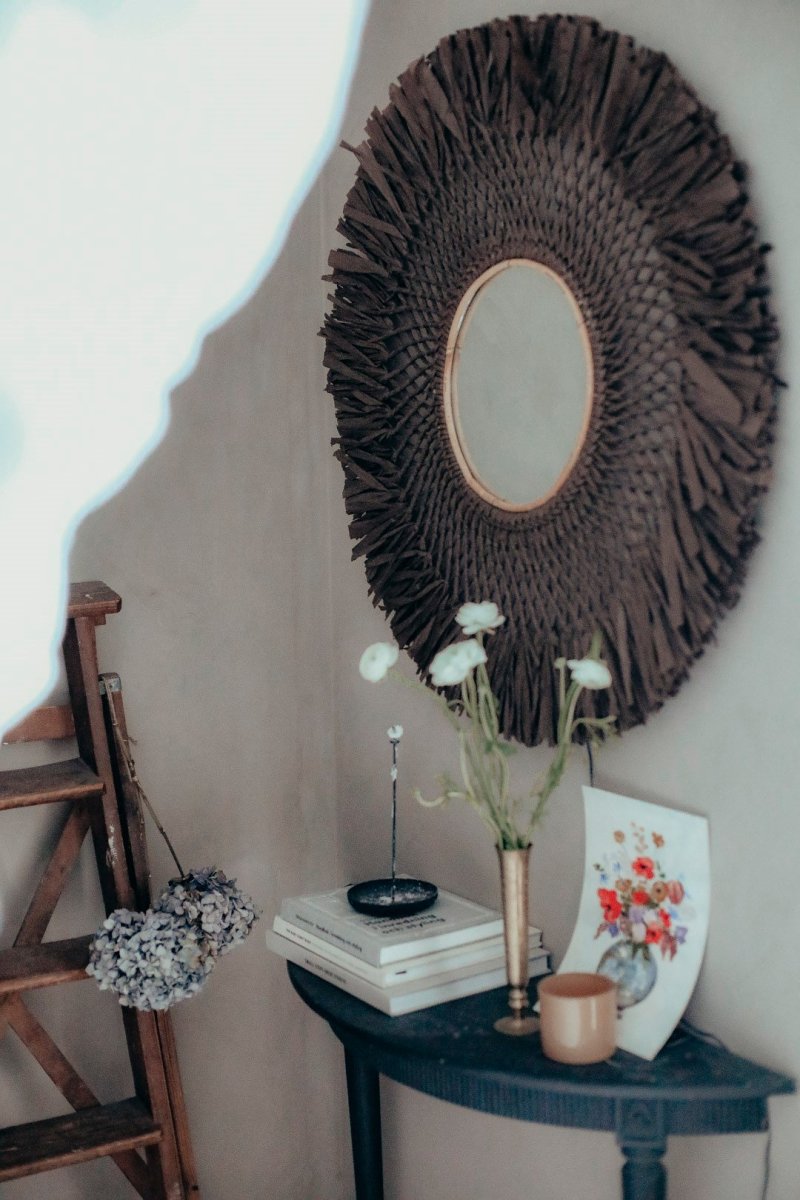 Spegel Ø90 Brun væglampe Fra Globen Lighting - Lampen er lavet af tyndt brunt papir, der er bundet i hånden, har et spejl i midten og en lille træring som en ekstra detalje.