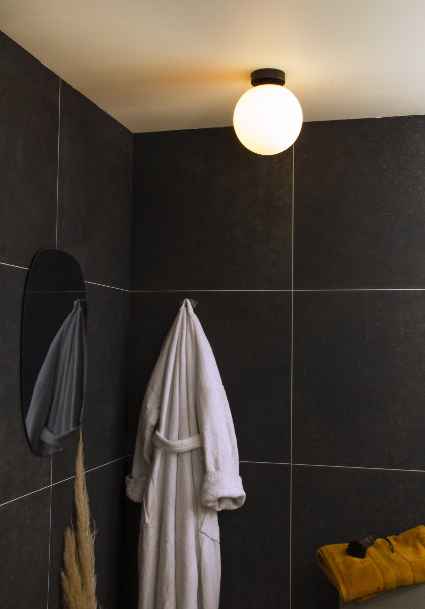 Lido Ø20 Sort badeværelseslampe Fra Aneta Lighting - Den matsorte metalramme er kombineret med en rund opalglasskærm, der spreder et blødt og behageligt lys.