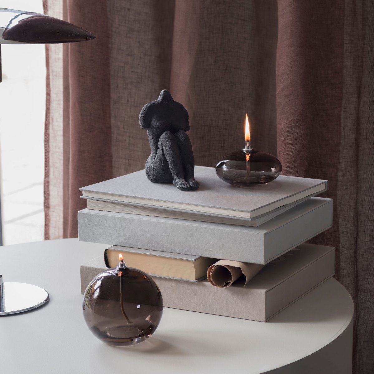 Oljelampa Aura Stor Røgfarvet Fra Mette Ditmer - Dess eleganta design och r&ouml;kf&auml;rgade glas sprider ett mjukt, varmt ljus som ger en lugn och mysig k&auml;nsla.