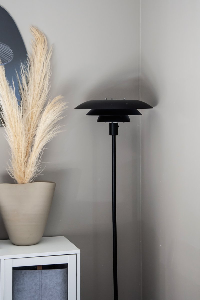 Epsilon Sort gulvlampe Fra Aneta Lighting - Stovlampen Epsilon har et klassisk design med sorte metalsk&aelig;rme i tre niveauer, der spreder lyset behageligt og forhindrer bl&aelig;nding.