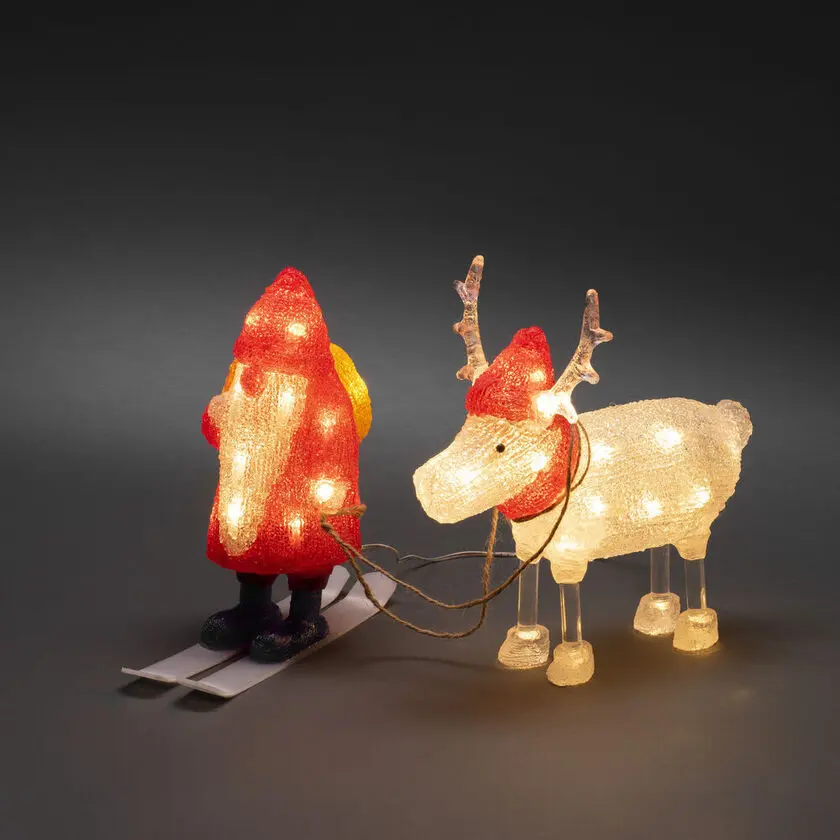 Tomte med ren akryl RØD Fra Konstsmide - Med 40 varme hvide LED-lys og detaljer som ski og julemandshue spreder figurerne b&aring;de humor og julestemning.