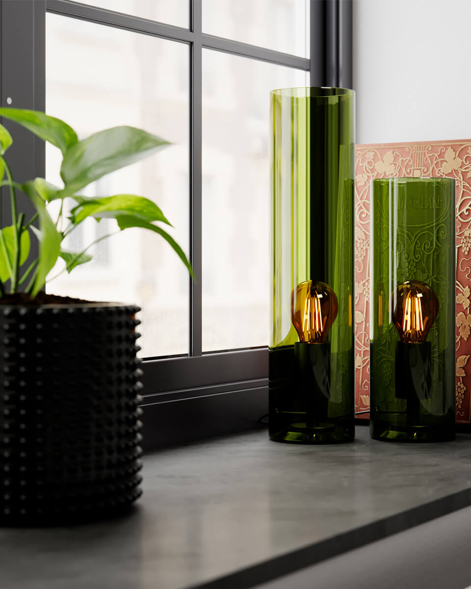 Flake 40cm Grøn bordlampe Fra By Rydéns - Med sit elegante cylinderformede glas og tilg&aelig;ngelighed i trendy farver som m&oslash;rk rav og gr&oslash;n, er Flake den perfekte lampe til at skabe stil og atmosf&aelig;re i dit hjem.