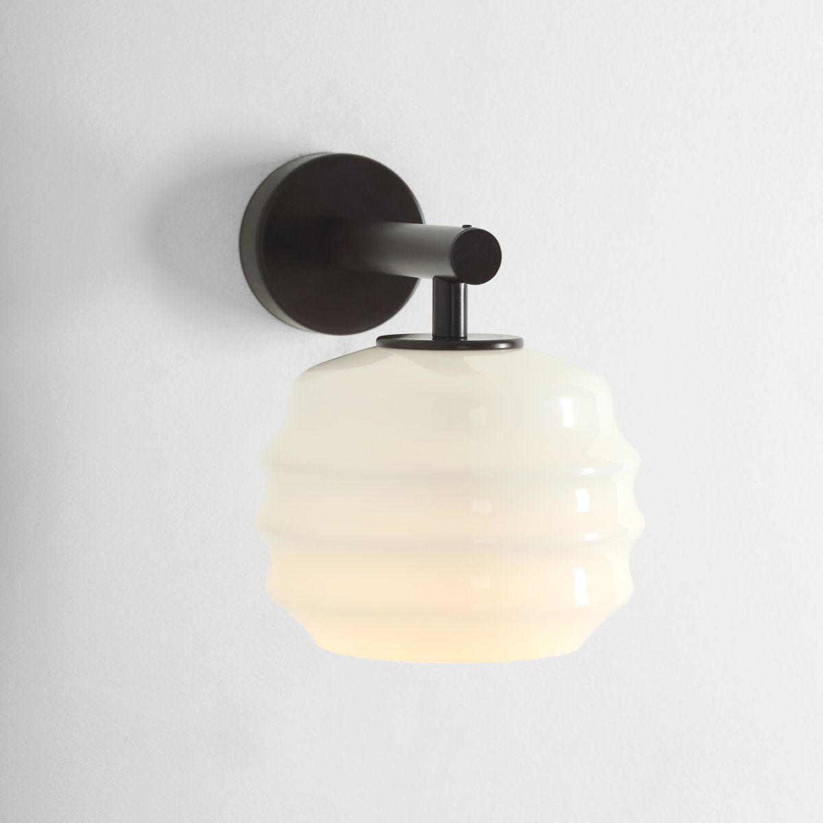 Puff 23cm Mørkebrun væglampe Fra Artera - Den dekorative skærm i hvidt opalglas har en bølget form, der giver lampen et legende og elegant udtryk.