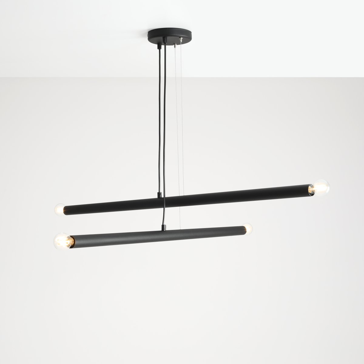 Tubo 4 100cm Sort loftslampe Fra Artera - Lampen består af to smalle metalrør i en stilfuld sort finish, placeret i forskellige vinkler, der skaber et spændende og luftigt udtryk.