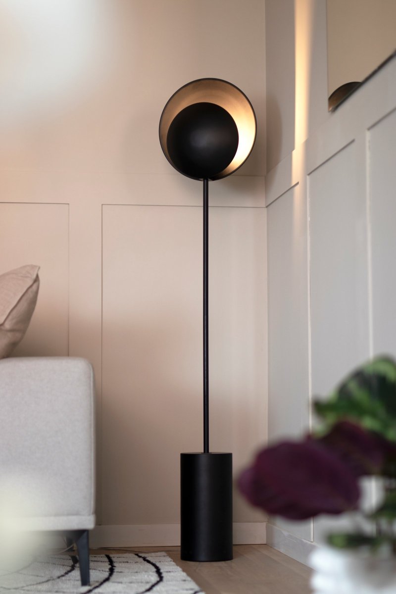 Orbit Sort gulvlampe Fra Globen Lighting - Lampen er monteret p&aring; en sort cylindrisk metalfod som giver den et elegant udtryk, stil den ved siden af sofaen eller i et hj&oslash;rne hvor du har brug for stemningsbelysning.