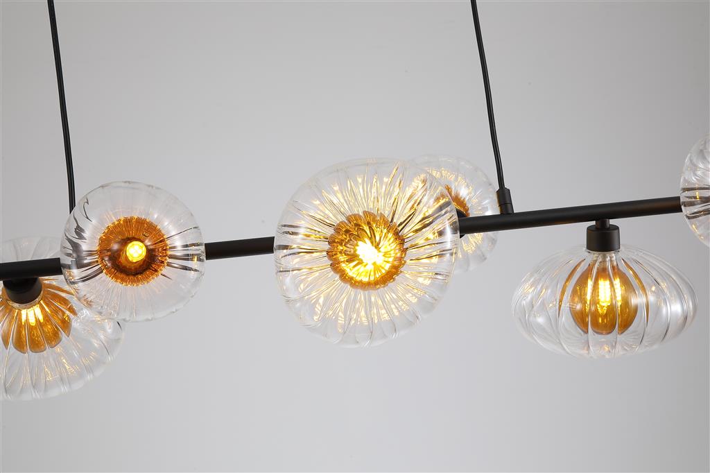 Sunbeam 90cm Gennemsigtig/sort loftslampe Fra Searchlight - Syv ribbede skærme i transparent glas med en varm ravfarvet kuppel indeni er placeret langs en matsort metalstang, hvilket skaber et udtryksfuldt design, der kombinerer funktion og dekorativ kunst.