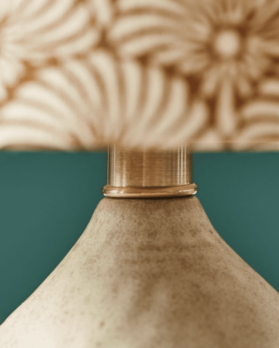 Flores 30cm Sand bordlampe Fra House Doctor - Den har en sandfarvet keramisk base og en hørlampeskærm prydet med håndtrykte sand- og brune viftemotiver, der smukt balancerer en moderne og hyggelig æstetik.