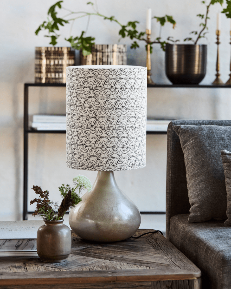 Florie 60cm Sand bordlampe Fra House Doctor - Den keramiske base i en beroligende sandskærm giver et stabilt og elegant fundament, mens hørlampeskærmen fremviser et håndtrykt sort etnisk mønster for en unik og kunstnerisk følelse.