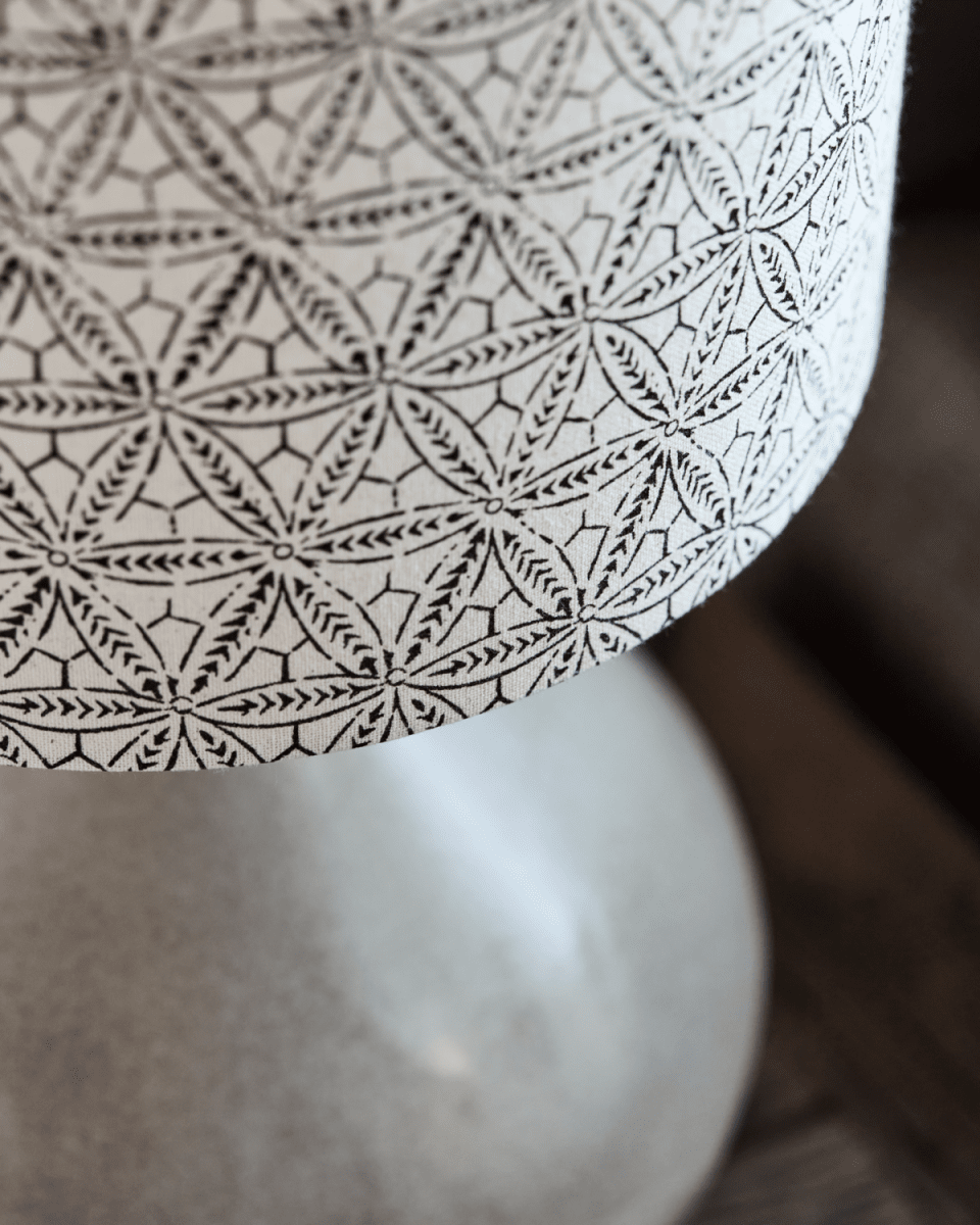 Florie 60cm Sand bordlampe Fra House Doctor - Den keramiske base i en beroligende sandskærm giver et stabilt og elegant fundament, mens hørlampeskærmen fremviser et håndtrykt sort etnisk mønster for en unik og kunstnerisk følelse.