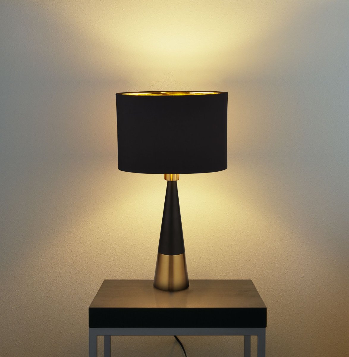 Chloe 40cm Mat sort bordlampe Fra Searchlight - Den ovale skærm med gyldent interiør skaber et varmt og behageligt lys, mens den slanke base med en kontrastfarvet gylden base tilføjer et sofistikeret touch.