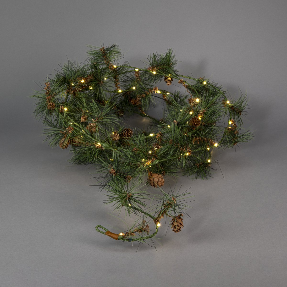 Guirlande 6m Grøn Fra Konstsmide - Skab en varm og indbydende vinterstemning med denne guirlande med kunstige fyrren&aring;le og sm&aring; kogler.