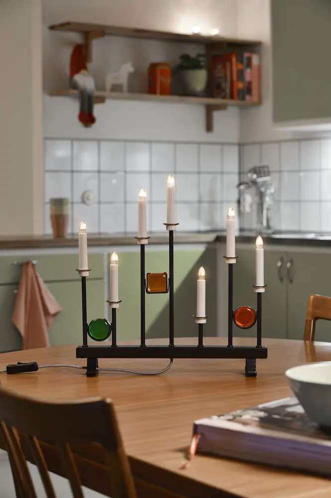 Candelabra 7 Lights Sort Fra Konstsmide - De syv lys er indrammet af dekorative farvede glasdetaljer i gr&oslash;n, r&oslash;d og rav, hvilket skaber en elegant og festlig atmosf&aelig;re.