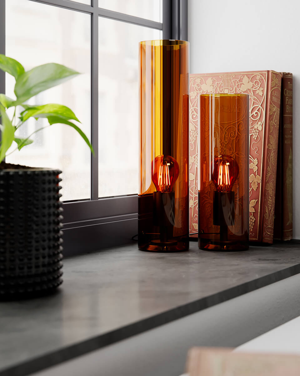 Flake 30cm Rav bordlampe Fra By Rydéns - Med sit elegante cylinderformede glas og tilg&aelig;ngelighed i trendy farver som m&oslash;rk rav og gr&oslash;n er Flake den perfekte lampe til at skabe stil og atmosf&aelig;re i dit hjem.