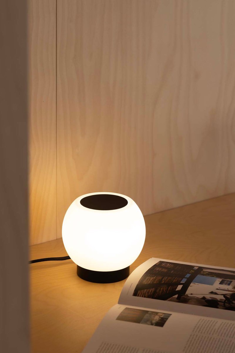 Moy 13cm Sort bordlampe Fra Faro Barcelona - Moy er en stilfuld, rund bordlampe i sort st&aring;l og hvidt glas, der giver et j&aelig;vnt og behageligt lys - perfekt til b&aring;de hjem og offentlige milj&oslash;er.