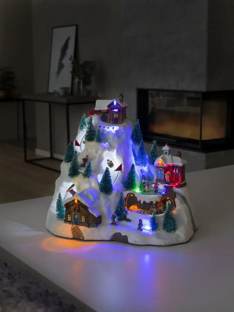 Mekanisk Juledekoration Med Bjerglandskab 28cm Flerfarvet Fra Konstsmide - Kom med til et glitrende vinterlandskab i bjergene med denne mekaniske juledekoration!