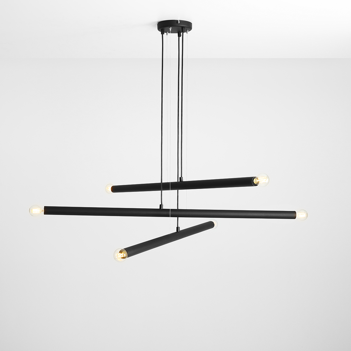 Tubo 6 100cm Sort loftslampe Fra Artera - Lampen består af tre smalle metalrør i en stilfuld sort finish, placeret i forskellige højder og vinkler, der skaber et spændende og luftigt udtryk.