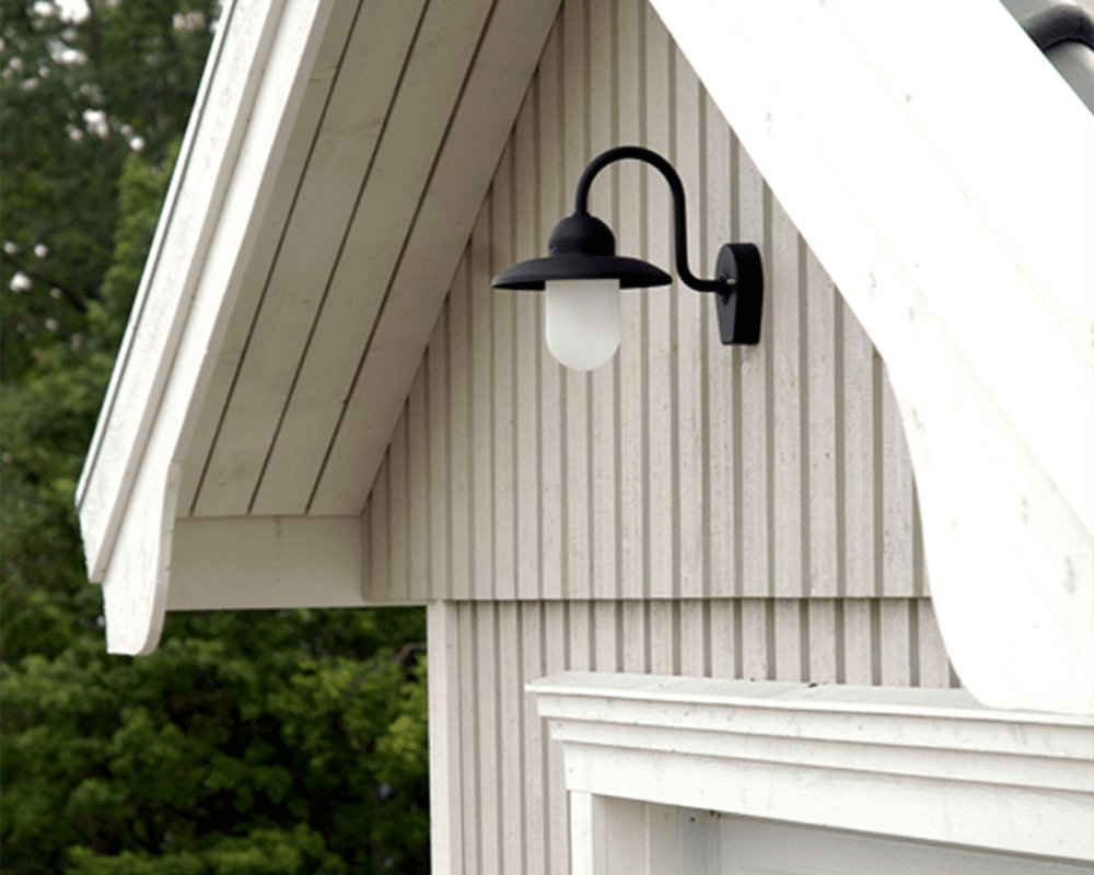 Nisse Sort udendørslampe Fra Westal - Nisee er en klassisk væglampe til udendørs brug, der kombinerer tidløst design med materialer af høj kvalitet.