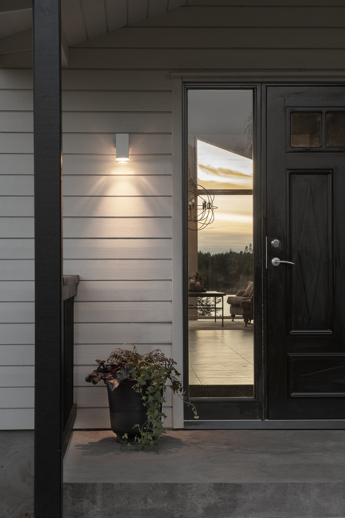 Pollux Hvid udendørslampe Fra Konstsmide - Med sit terningformede design og direkte lys er den ideel til at skabe en sofistikeret atmosfære i entre og gange.