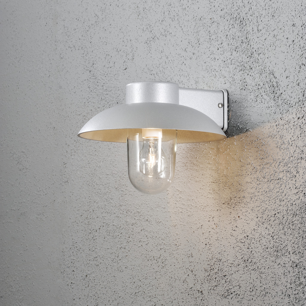 Mani Grå udendørslampe Fra Konstsmide - Den brede skærm og den klare glaskuppel spreder et behageligt og rettet lys, som gør lampen perfekt til entre og terrasser.