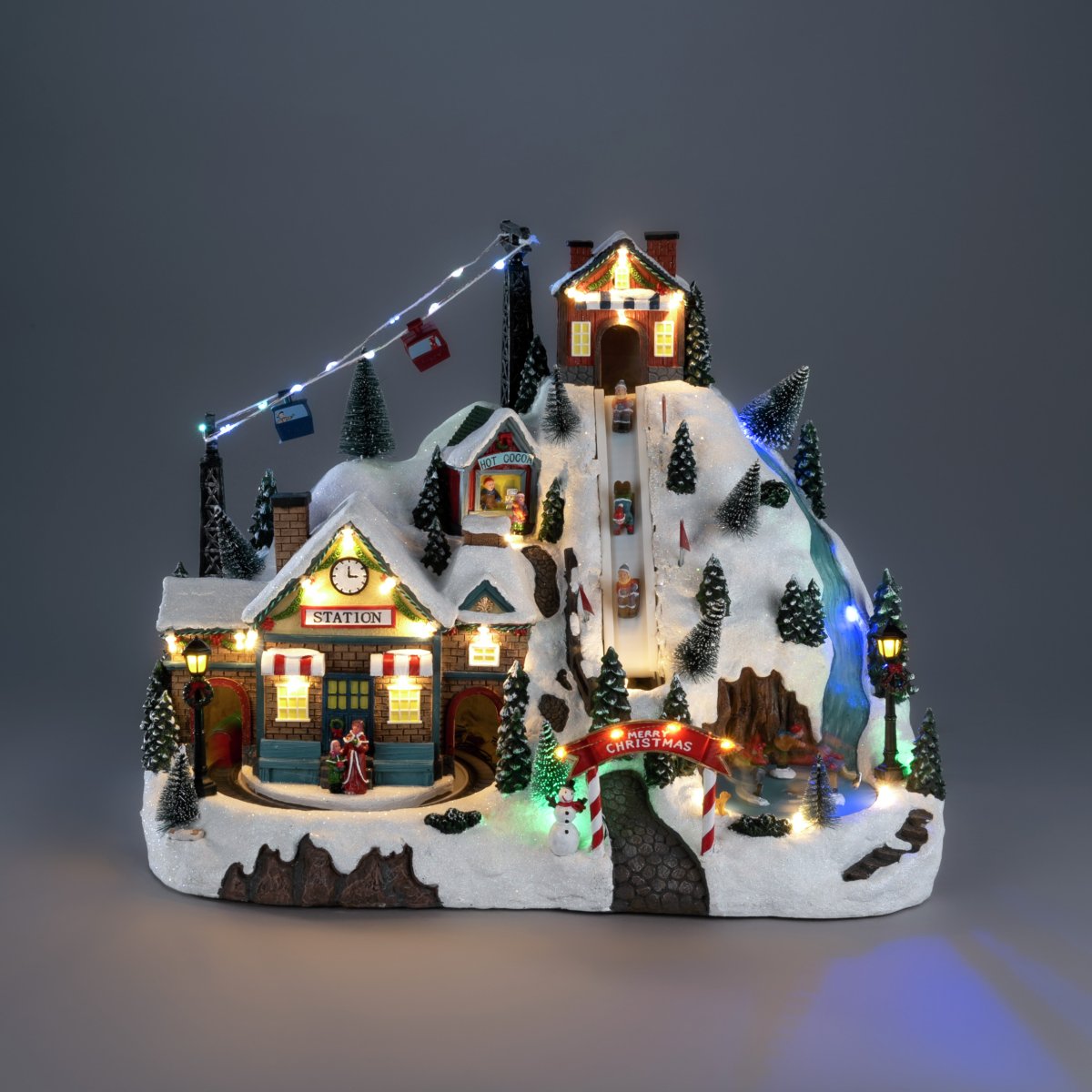 Juleby Skisted 28cm Flerfarvet Fra Konstsmide - Skab en levende og magisk julestemning med denne detaljerede julelandsby formet som et skisportssted, lavet af polyresin.