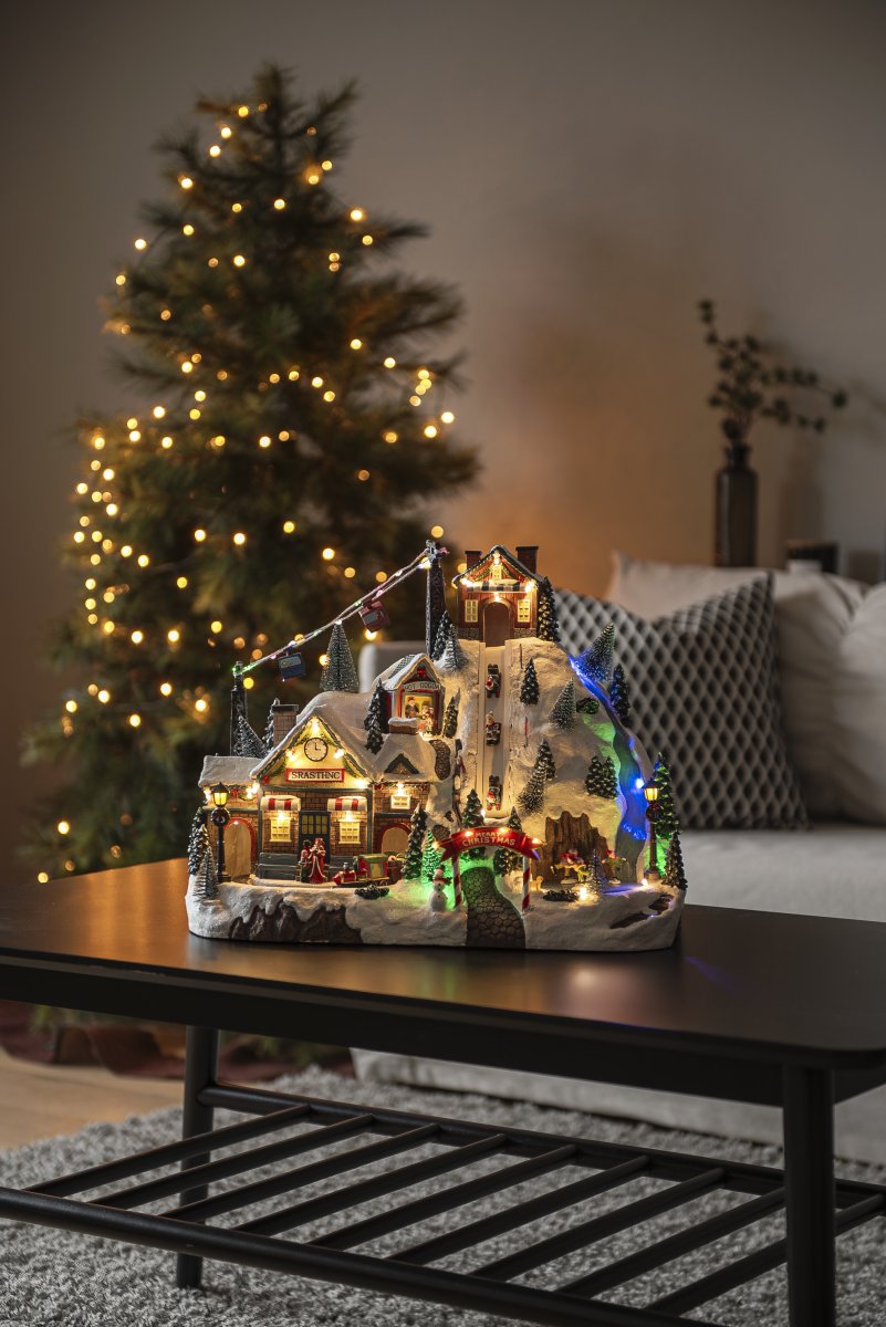 Juleby Skisted 28cm Flerfarvet Fra Konstsmide - Skab en levende og magisk julestemning med denne detaljerede julelandsby formet som et skisportssted, lavet af polyresin.