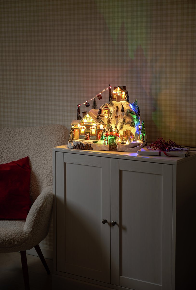 Juleby Skisted 28cm Flerfarvet Fra Konstsmide - Skab en levende og magisk julestemning med denne detaljerede julelandsby formet som et skisportssted, lavet af polyresin.