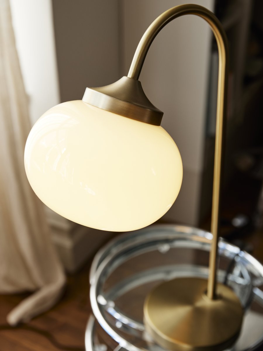 Elsy 50cm Børstet messing bordlampe Fra PR Home - Den h&aring;ndlavede glassk&aelig;rm i en bl&oslash;d, cremehvid sk&aelig;rm giver hver lampe en unik karakter, mens de b&oslash;rstede messingdetaljer skaber en stilfuld og tidl&oslash;s helhed.