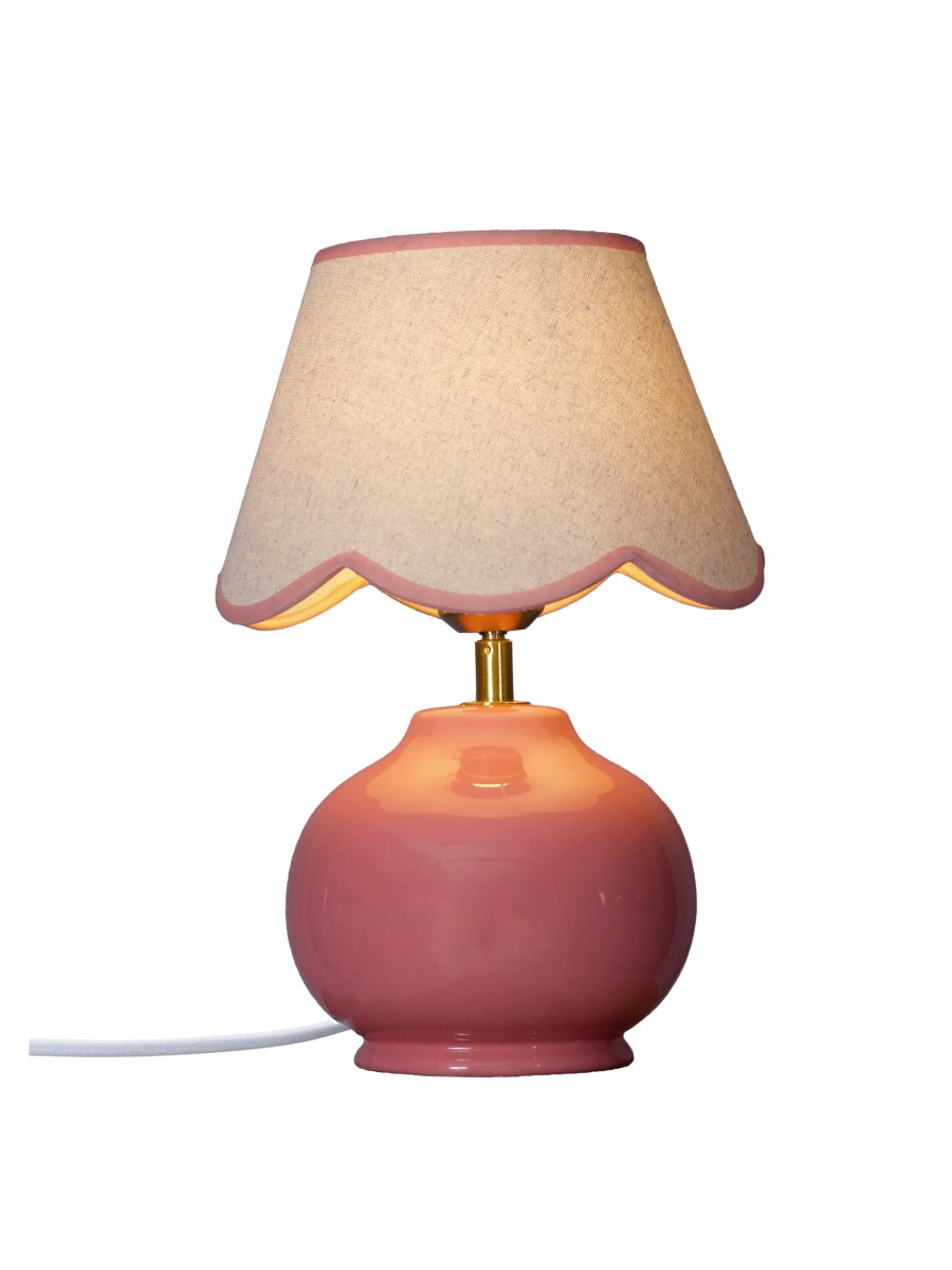 Nell 34cm Lyserød bordlampe Fra PR Home - Den sf&aelig;riske lampefod i blank, lyser&oslash;d er kombineret med en beige tekstilsk&aelig;rm, der giver et bl&oslash;dt og harmonisk udtryk, perfekt til b&aring;de sovev&aelig;relser og stuer.