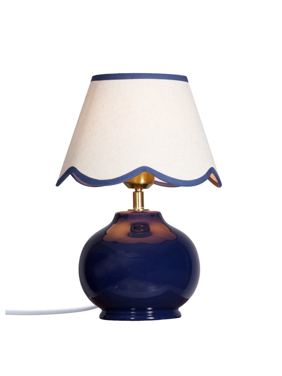 Nell 34cm Blå bordlampe Fra PR Home - Den sf&aelig;riske lampefod i en blank, dybbl&aring; farve er kombineret med en beige tekstilsk&aelig;rm, der giver et bl&oslash;dt og harmonisk udtryk, perfekt til b&aring;de sovev&aelig;relser og stuer.