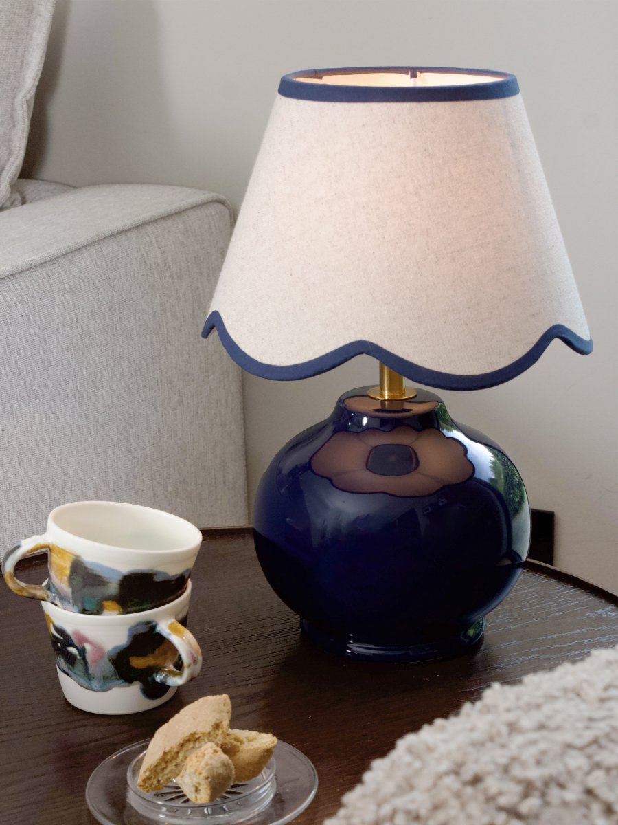 Nell 34cm Blå bordlampe Fra PR Home - Den sf&aelig;riske lampefod i en blank, dybbl&aring; farve er kombineret med en beige tekstilsk&aelig;rm, der giver et bl&oslash;dt og harmonisk udtryk, perfekt til b&aring;de sovev&aelig;relser og stuer.