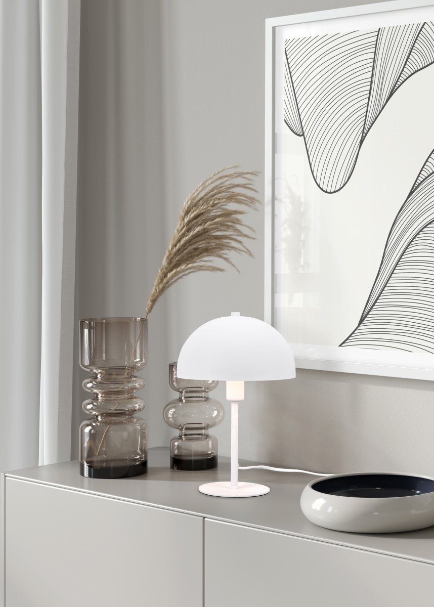 Nola 30cm Hvid bordlampe Fra Trio Lighting - Den moderne, svampeformede form passer ind i dit interiør og skaber harmoni på en byr&aring; eller natborde.